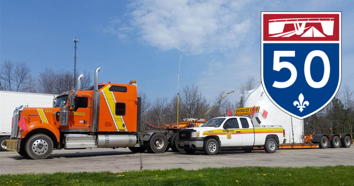 An oversize load convoy from Groupe Bellemare stuck on Highway 50 due to unannounced concrete barriers from a construction site.