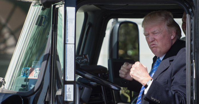 Donald Trump seated in a truck, symbolizing discussions around proposed tariffs and their potential impact on trucking and the North American economy.